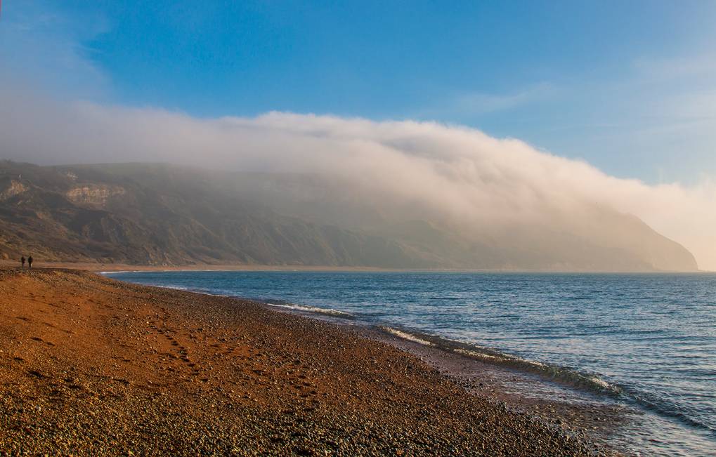 Weymouth, Dorset, Autumnal land fog dissipating over the warmer sea. ...